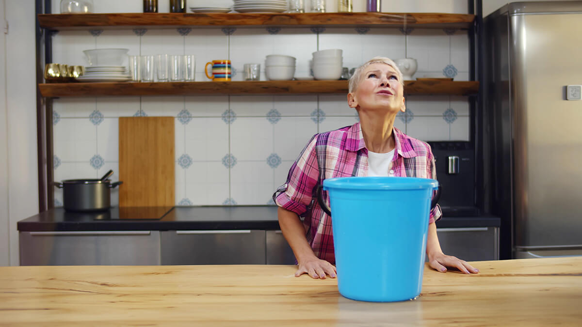 Worried aged woman holding bucket